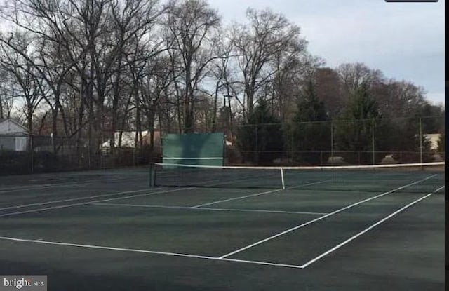 view of tennis court featuring fence
