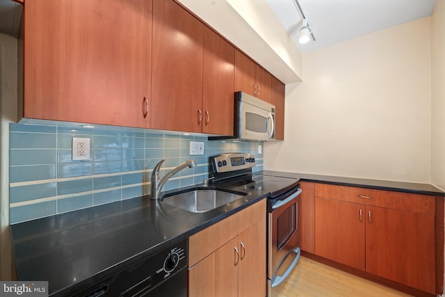 1301 N Ode St Unit 135, Arlington, VA 22209 - kitchen featuring appliances with stainless steel finishes, a sink, backsplash, dark stone counters, and light wood-style flooring