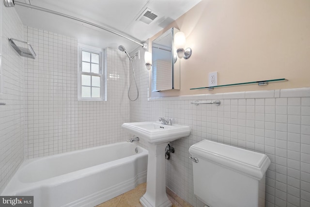 1301 N Ode St Unit 135, Arlington, VA 22209 - bathroom featuring toilet,  shower combination, tile walls, wainscoting, and tile patterned flooring