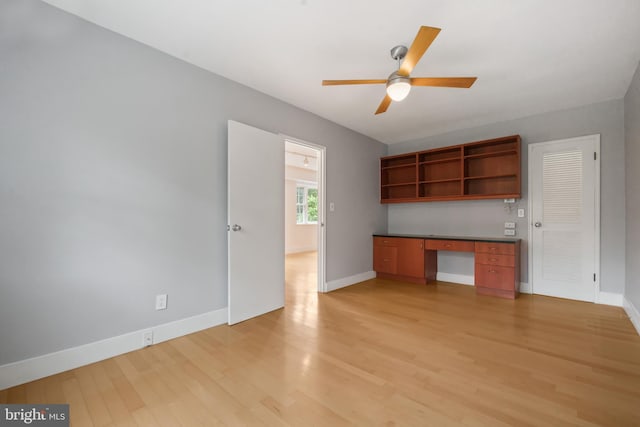 1301 N Ode St Unit 135, Arlington, VA 22209 - kitchen with open shelves, light wood finished floors, baseboards, dark countertops, and ceiling fan