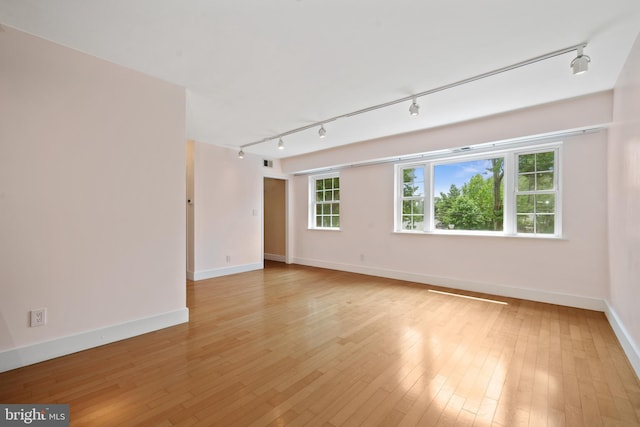 1301 N Ode St Unit 135, Arlington, VA 22209 - empty room with track lighting, baseboards, and light wood-type flooring