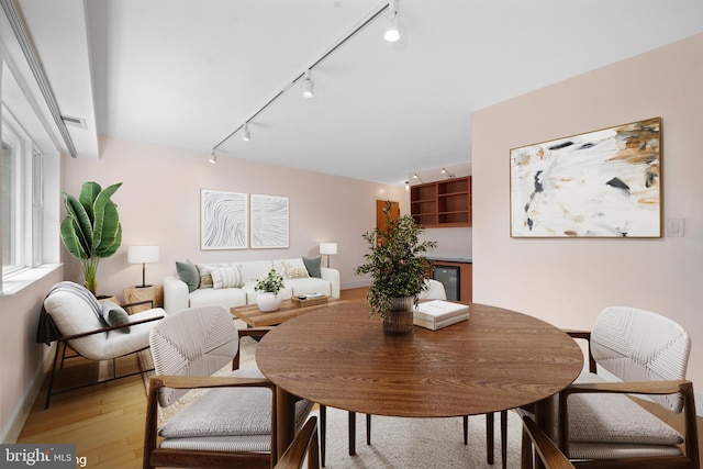 1301 N Ode St Unit 135, Arlington, VA 22209 - dining room featuring track lighting, light wood-style flooring, baseboards, and wine cooler