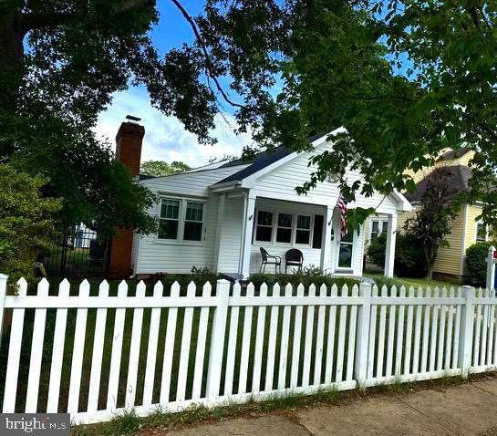 bungalow with a chimney and a fenced front yard