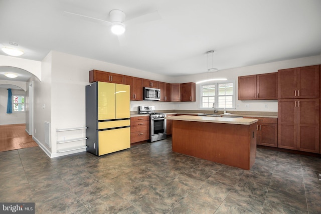 1417 Franklin St, Fredericksburg, VA 22401 - kitchen featuring appliances with stainless steel finishes, light countertops, arched walkways, a ceiling fan, and a kitchen island