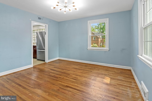 6248 Woodcrest Ave, Baltimore, MD 21209 - empty room with baseboards, wood finished floors, a notable chandelier, and visible vents