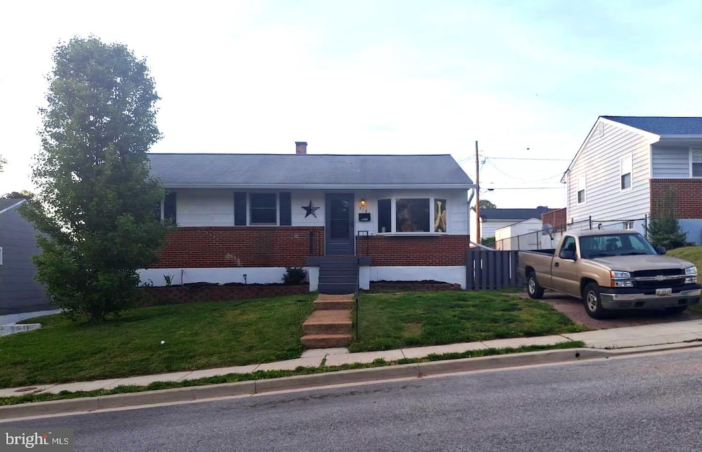 bungalow-style house with brick siding and a front yard