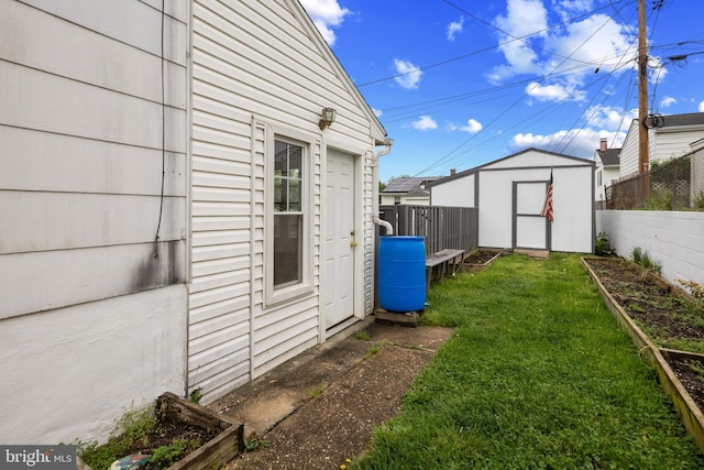 310 18th Ave, Baltimore, MD 21225 - view of yard featuring a storage unit, a fenced backyard, a garden, and an outbuilding