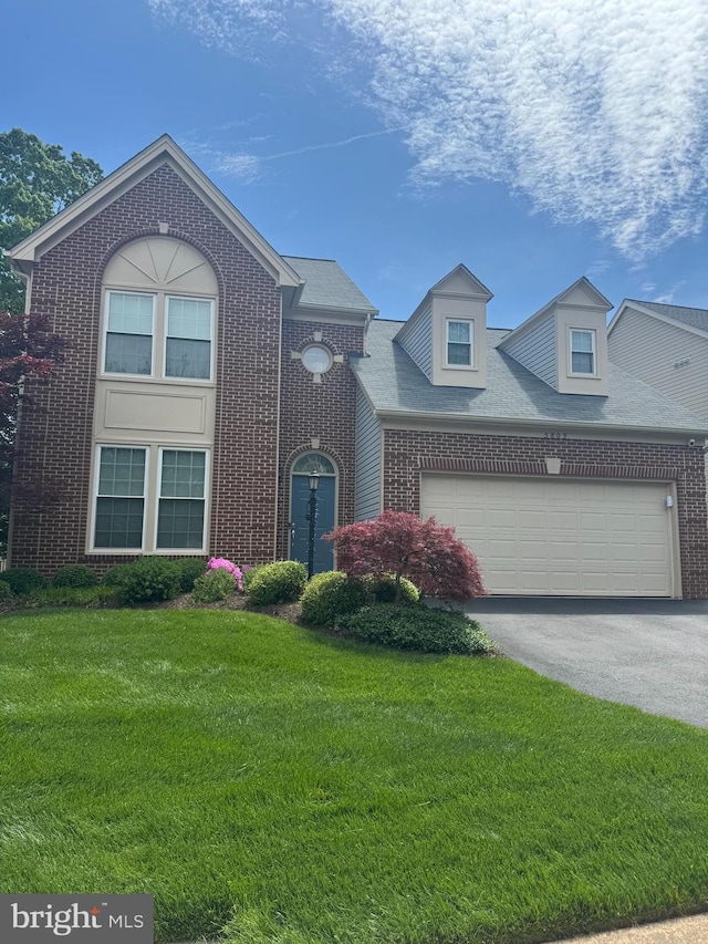 traditional home with brick siding, a garage, driveway, and a front lawn