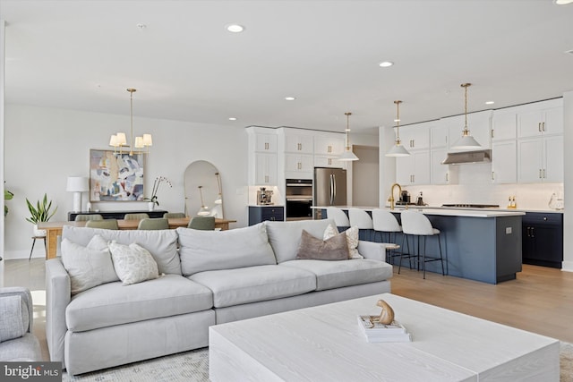9 Mill Creek Dr, Doylestown, PA 18901 - living room with recessed lighting, arched walkways, a notable chandelier, and light wood-type flooring