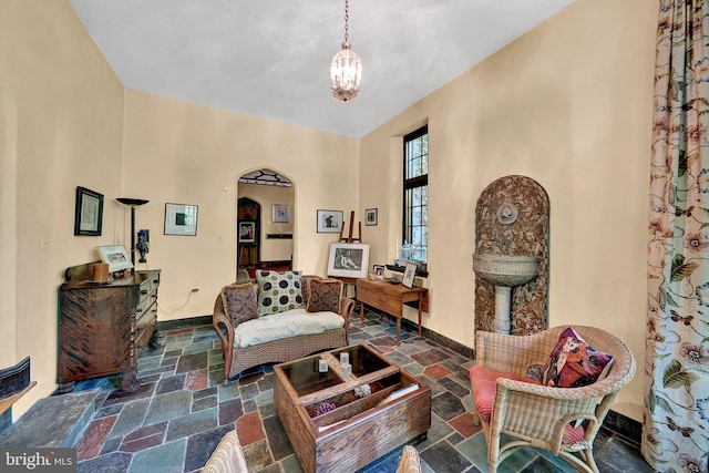 218 Parkside Ave, Trenton, NJ 08618 - living area featuring stone tile flooring, arched walkways, a chandelier, and baseboards