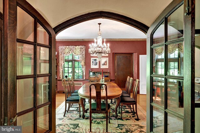 218 Parkside Ave, Trenton, NJ 08618 - dining space featuring a chandelier, light wood finished floors, arched walkways, and ornamental molding
