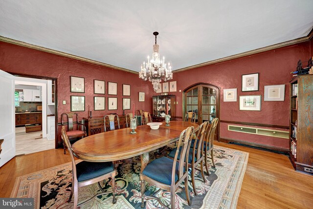 218 Parkside Ave, Trenton, NJ 08618 - dining area featuring a chandelier, light wood-type flooring, a textured wall, and arched walkways
