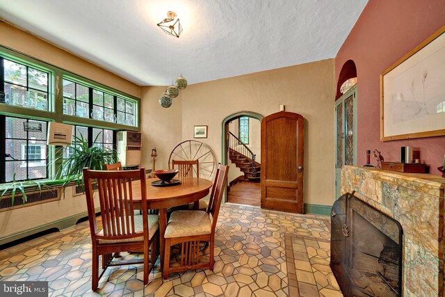 218 Parkside Ave, Trenton, NJ 08618 - dining area with a fireplace, light stone finish floors, stairway, and a textured ceiling
