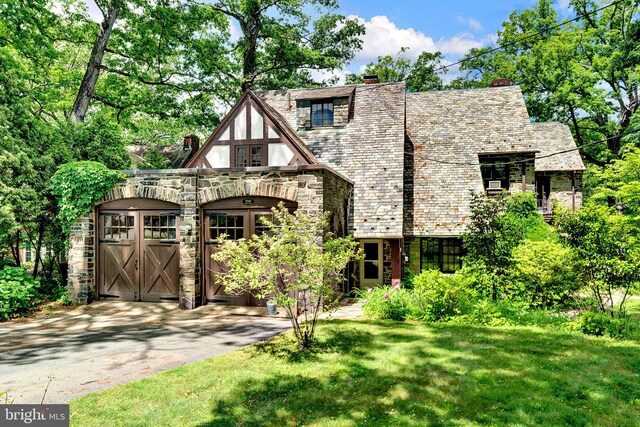 218 Parkside Ave, Trenton, NJ 08618 - tudor house with stone siding, a chimney, a high end roof, and a front yard