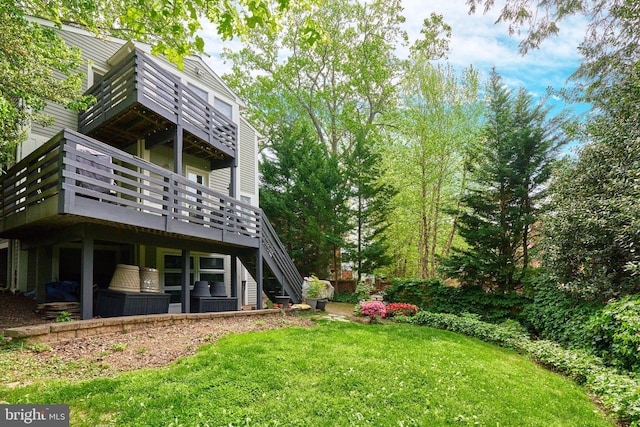 view of grassy yard with stairway and a deck
