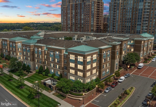 view of building exterior with central AC unit and uncovered parking