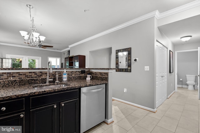 kitchen with an inviting chandelier, dishwasher, dark cabinets, a sink, and backsplash