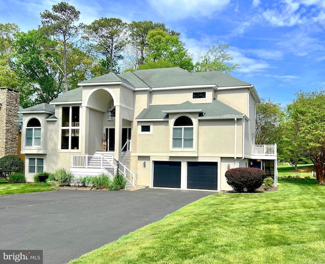 view of front of property featuring stucco siding, asphalt driveway, an attached garage, a front lawn, and stairway