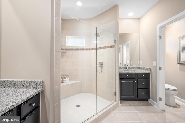 full bathroom with vanity, toilet, tile patterned floors, baseboards, and a stall shower