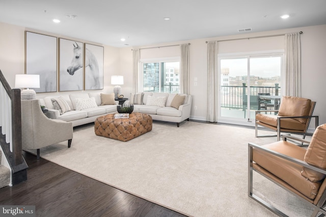 living room with recessed lighting, wood finished floors, and visible vents