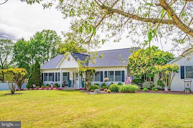view of front of house with a front yard and roof with shingles