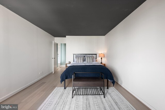 bedroom with wood finished floors and baseboards