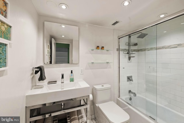bathroom with toilet, bath / shower combo with glass door, and recessed lighting
