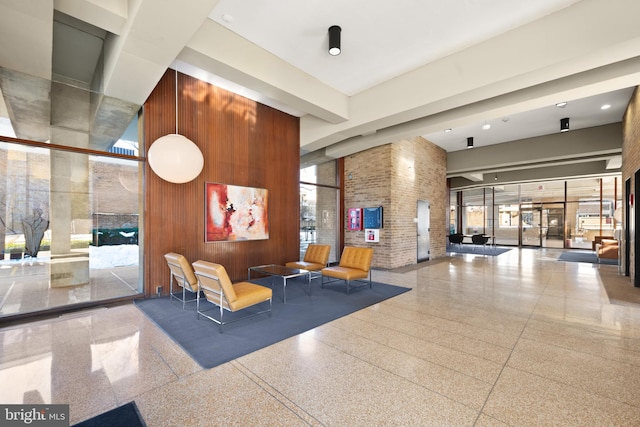 community lobby featuring a towering ceiling and wood walls