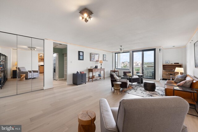 living area with light wood finished floors and a ceiling fan