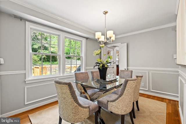 708 W Timber Branch Pkwy, Alexandria, VA 22302 - dining room featuring a chandelier, healthy amount of natural light, ornamental molding, wood finished floors, and a wainscoted wall