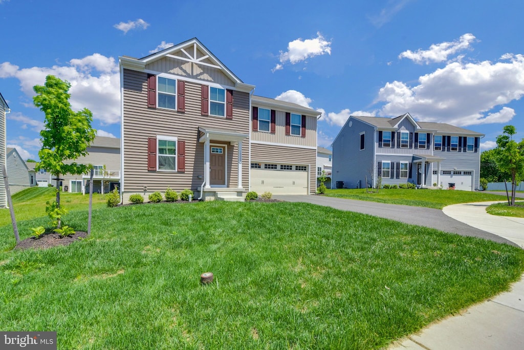 view of front of property with an attached garage, board and batten siding, aphalt driveway, and a front yard