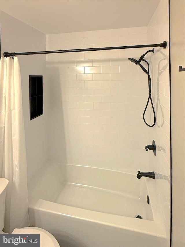 bathroom featuring toilet and shower / bath combo