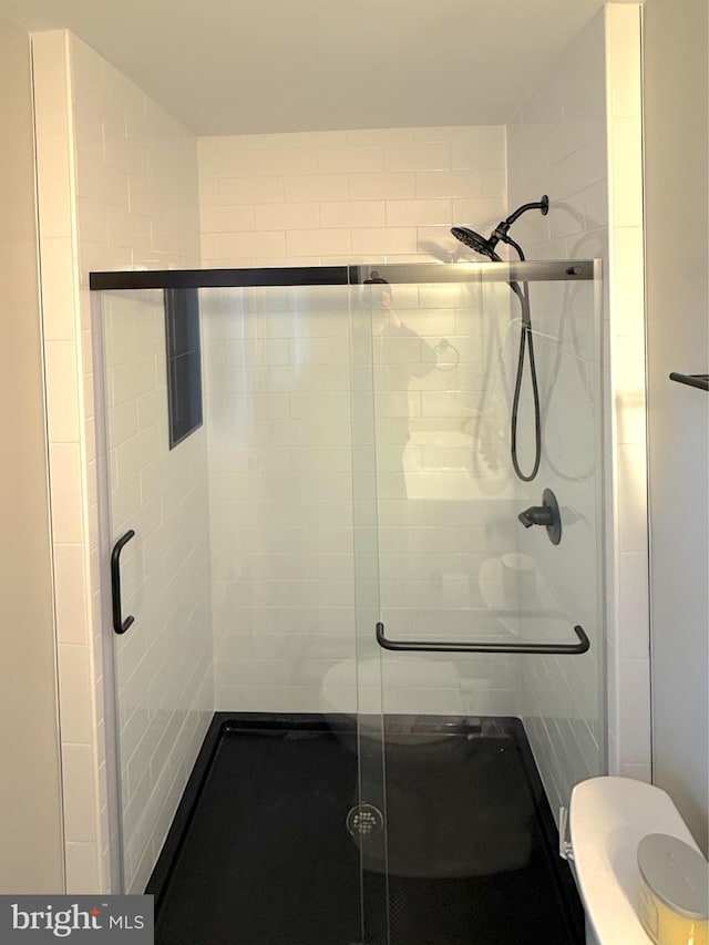 full bathroom featuring a stall shower and toilet