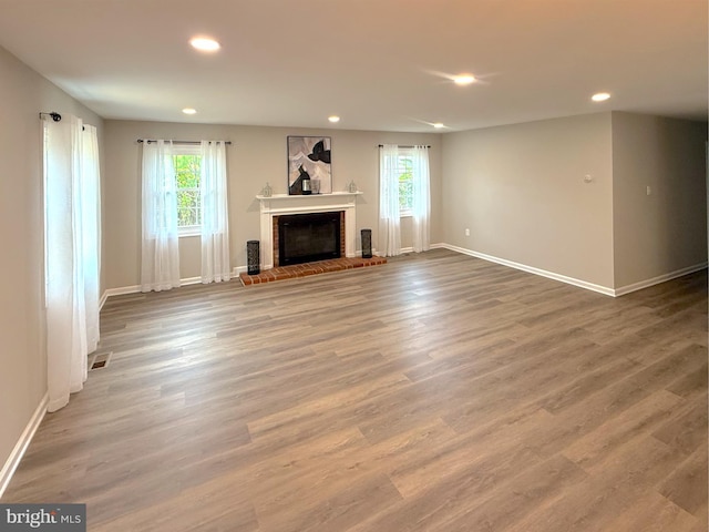 unfurnished living room featuring visible vents, a fireplace, a healthy amount of sunlight, and recessed lighting