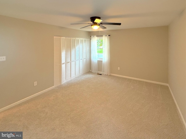 unfurnished room featuring light carpet, baseboards, a ceiling fan, and visible vents