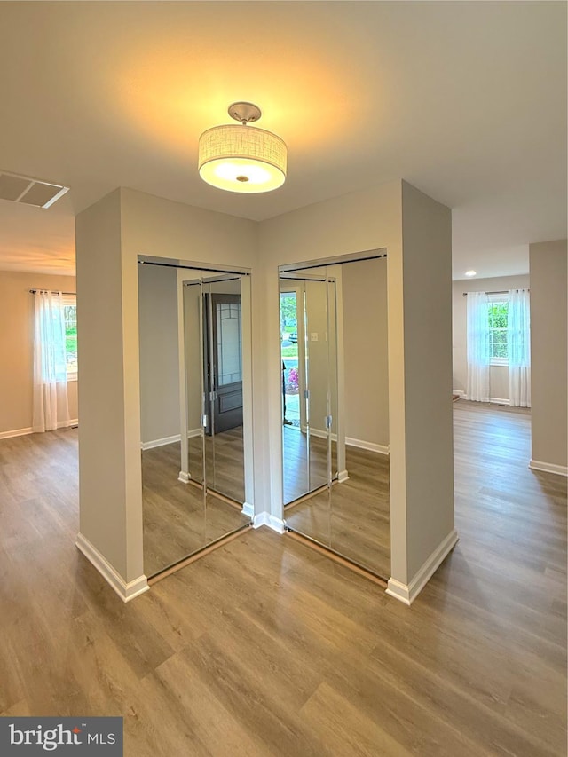 interior space featuring baseboards, visible vents, and wood finished floors