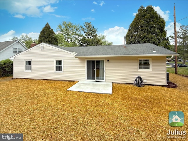 rear view of house with a patio, a shingled roof, and a lawn