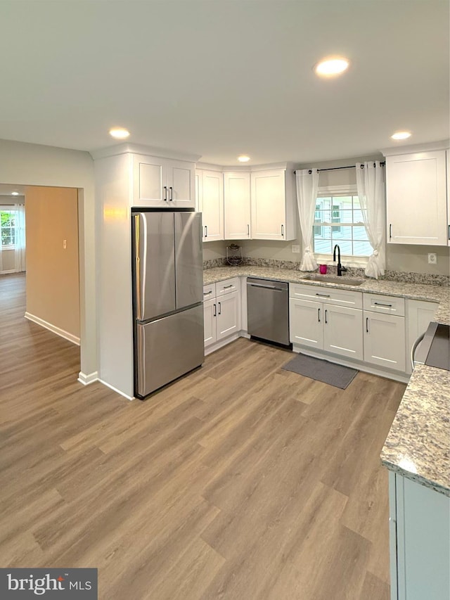 kitchen with a sink, white cabinetry, and appliances with stainless steel finishes