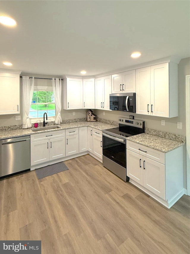 kitchen with recessed lighting, white cabinets, appliances with stainless steel finishes, and a sink