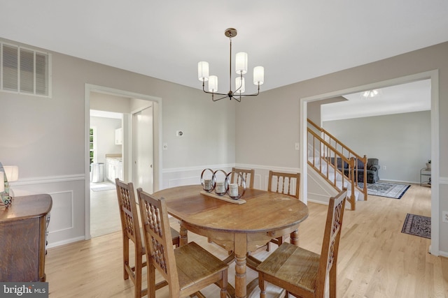 73 Mcpherson Cir, Sterling, VA 20165 - dining space featuring light wood-style floors, stairway, a chandelier, and wainscoting