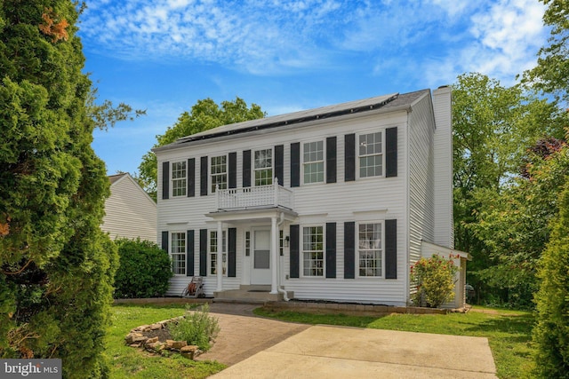73 Mcpherson Cir, Sterling, VA 20165 - view of front facade with a balcony, solar panels, a chimney, and a front yard