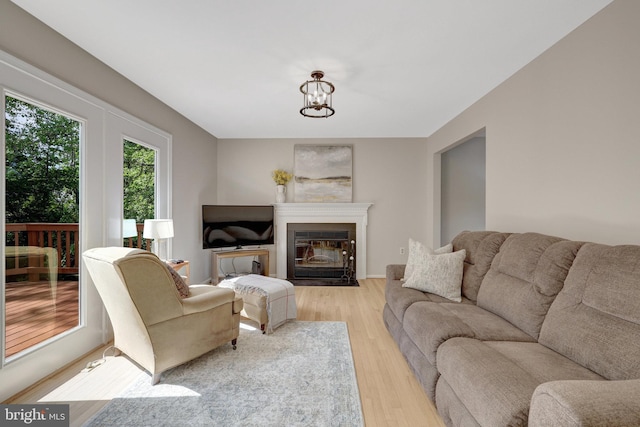 73 Mcpherson Cir, Sterling, VA 20165 - living area with light wood-style floors, a chandelier, and a fireplace with flush hearth
