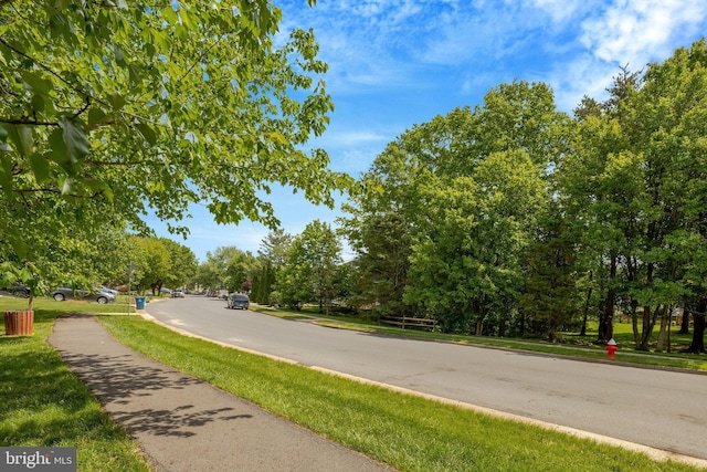 73 Mcpherson Cir, Sterling, VA 20165 - view of asphalt road featuring sidewalks, curbs, and view of wooded area