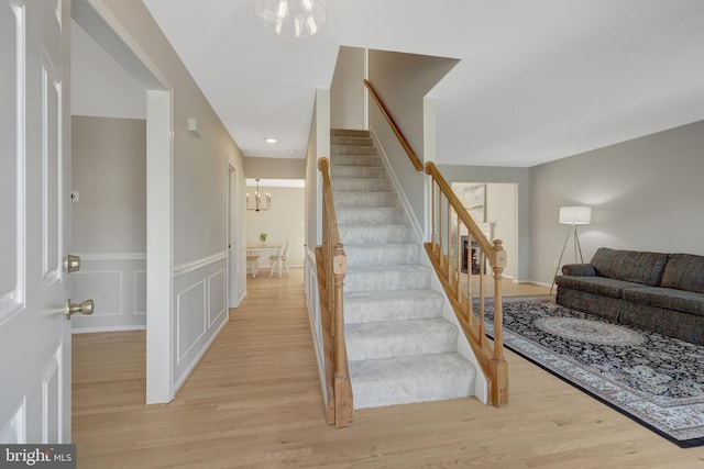 73 Mcpherson Cir, Sterling, VA 20165 - stairway featuring a chandelier, wood finished floors, a wainscoted wall, and recessed lighting