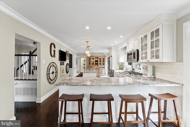kitchen featuring white cabinets, appliances with stainless steel finishes, dark wood finished floors, baseboards, and glass insert cabinets