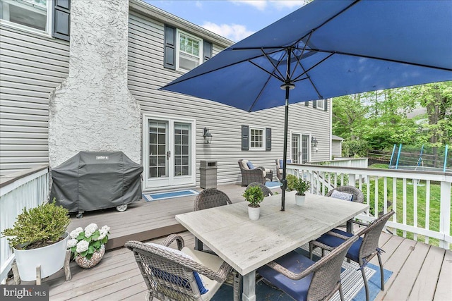 wooden deck featuring grilling area and outdoor dining space