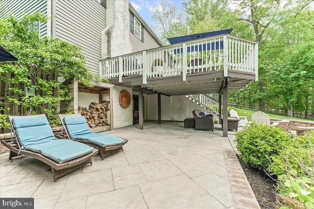 view of patio featuring stairway, fence, and a wooden deck