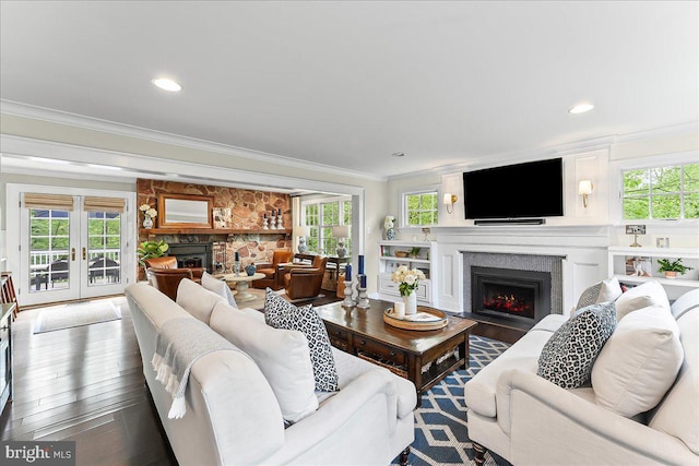 living room featuring a fireplace with flush hearth, crown molding, and a healthy amount of sunlight
