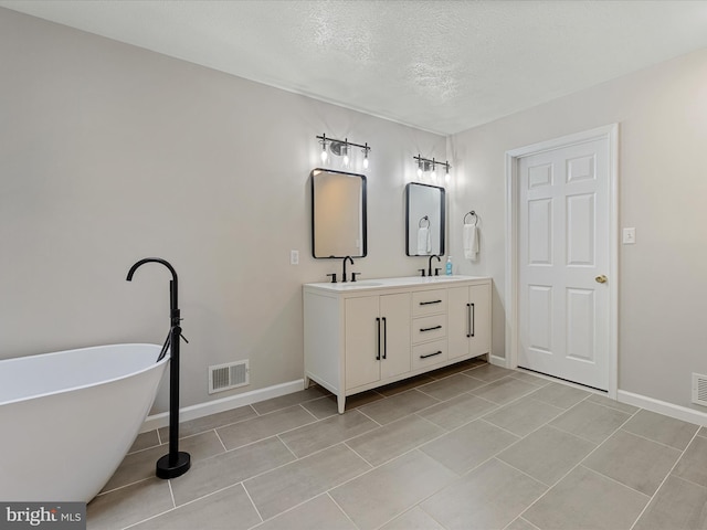 112 Rebels Cir, Winchester, VA 22602 - bathroom featuring double vanity, a textured ceiling, baseboards, a soaking tub, and tile patterned flooring