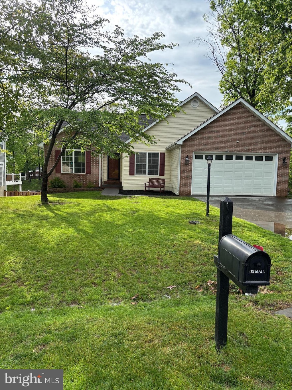 single story home with a front lawn, brick siding, and an attached garage